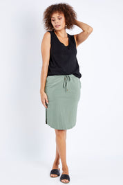 Model Lala wearing size 10 of The Drawcord Skirt in colour Khaki (Green), from the front, showing the whole outfit