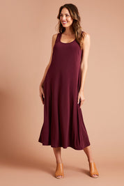 Model Madeline wearing size 10 of The Recycled A Line Midi Dress in colour Burntplum (Purple), from the front, showing the whole outfit