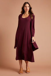 Model Madeline wearing size 10 of The Recycled A Line Midi Dress in colour Burntplum (Purple), from the front, showing the whole outfit