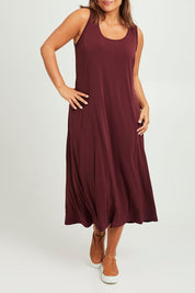 Model Monique wearing size 14 of The Recycled A Line Midi Dress in colour Burntplum (Purple), from the front, cropped image
