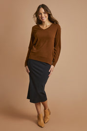 Model Madeline wearing size 10 of The Ponte Pull On Midi Skirt in colour Black (Black), from the front, showing the whole outfit