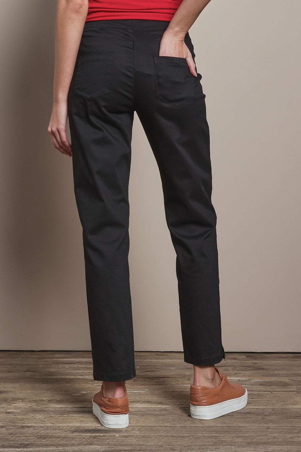 Model Madeline wearing size 10 of The 7/8 Pull On Pant in colour Black (Black), from the back