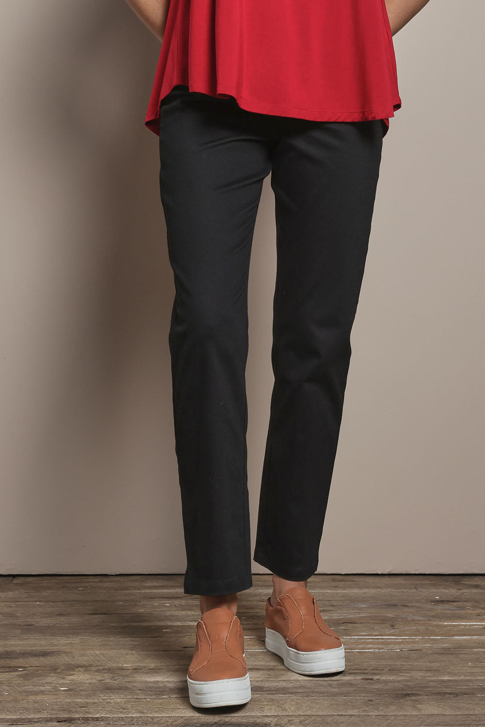 Model Madeline wearing size 10 of The 7/8 Pull On Pant in colour Black (Black), from the front, cropped image