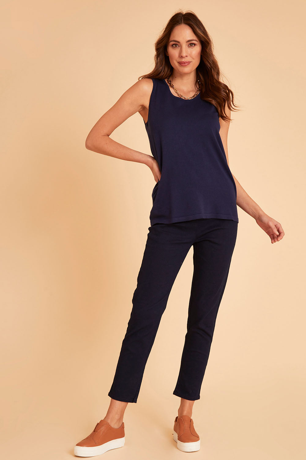 Model Madeline wearing size 10 of The 7/8 Pull On Pant in colour Darkdenim (Blue), from the front, showing the whole outfit