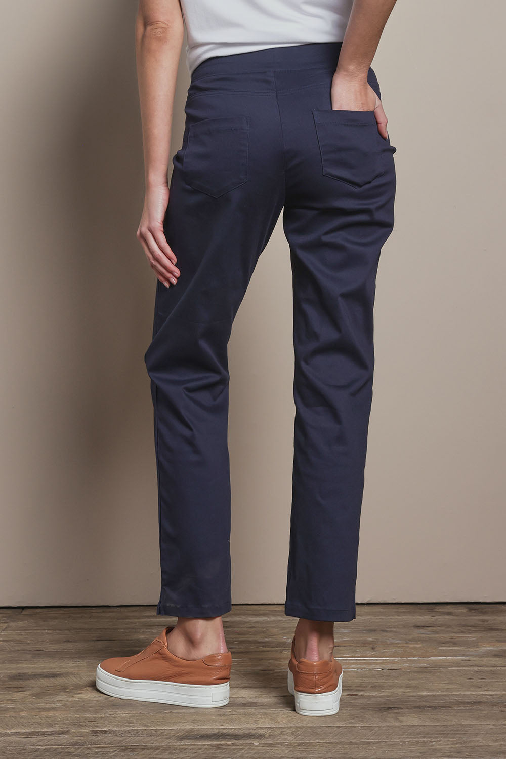 Model Madeline wearing size 10 of The 7/8 Pull On Pant in colour Darknavy (Blue), from the back