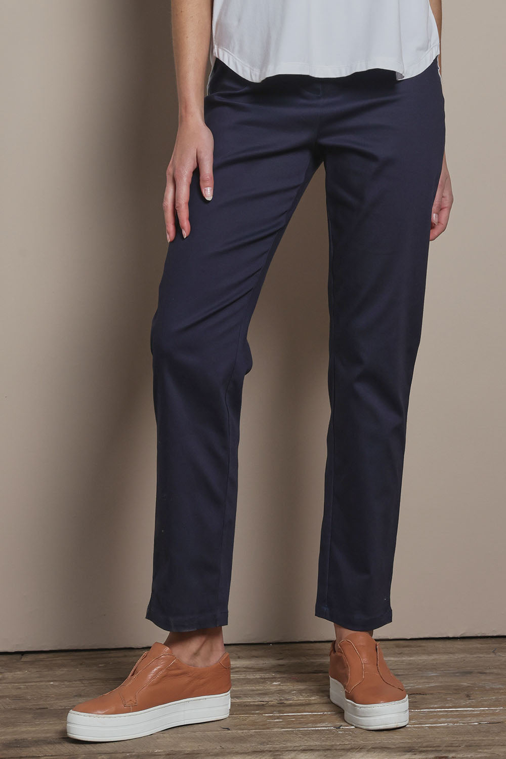 Model Madeline wearing size 10 of The 7/8 Pull On Pant in colour Darknavy (Blue), from the front, cropped image