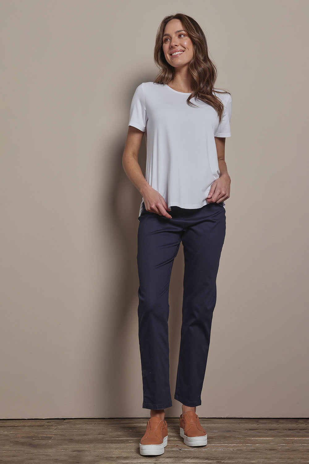 Model Madeline wearing size 10 of The 7/8 Pull On Pant in colour Darknavy (Blue), from the front, showing the whole outfit