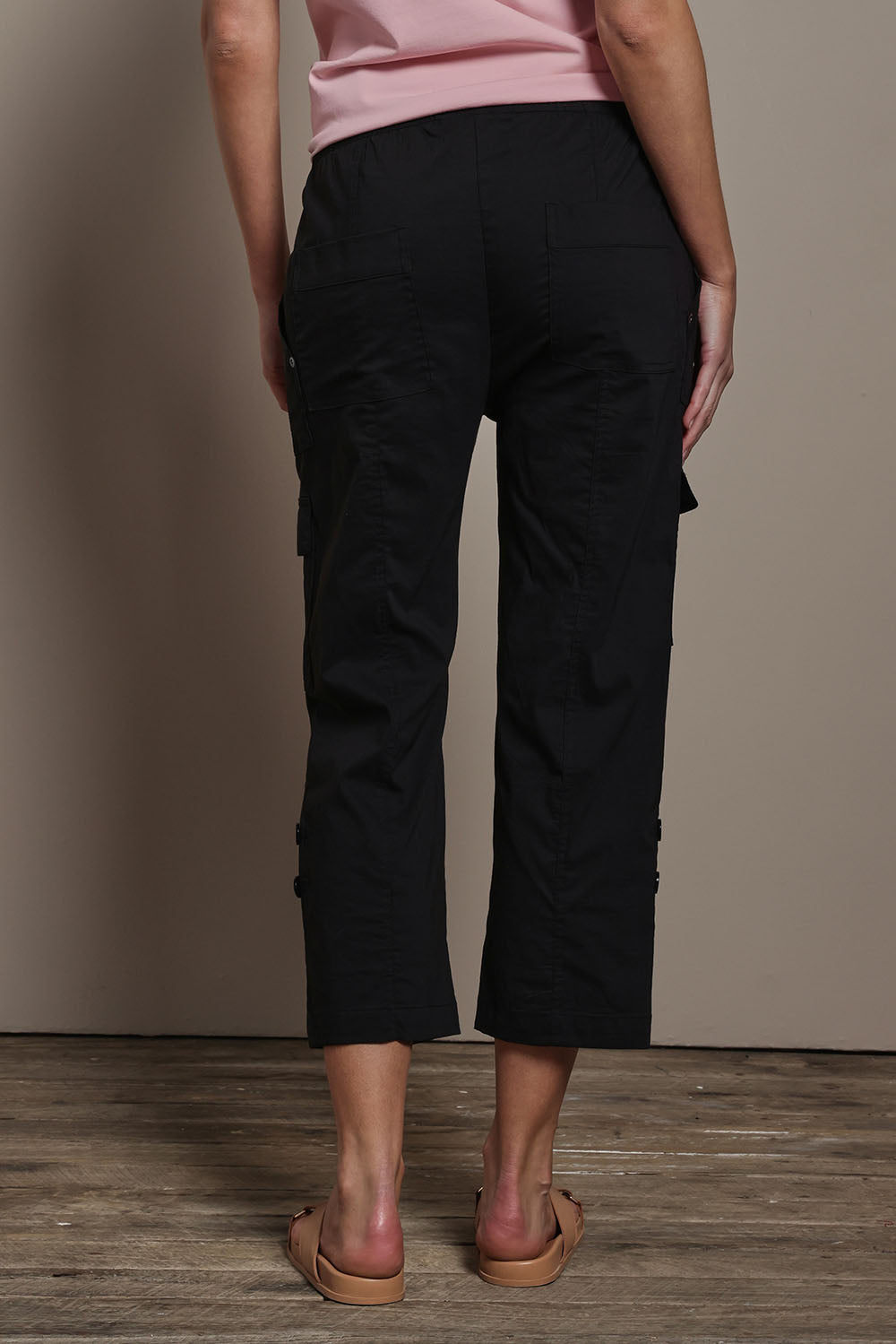 Model Madeline wearing size 10 of The Cotton Blend Cargo Pant in colour Black (Black), from the back
