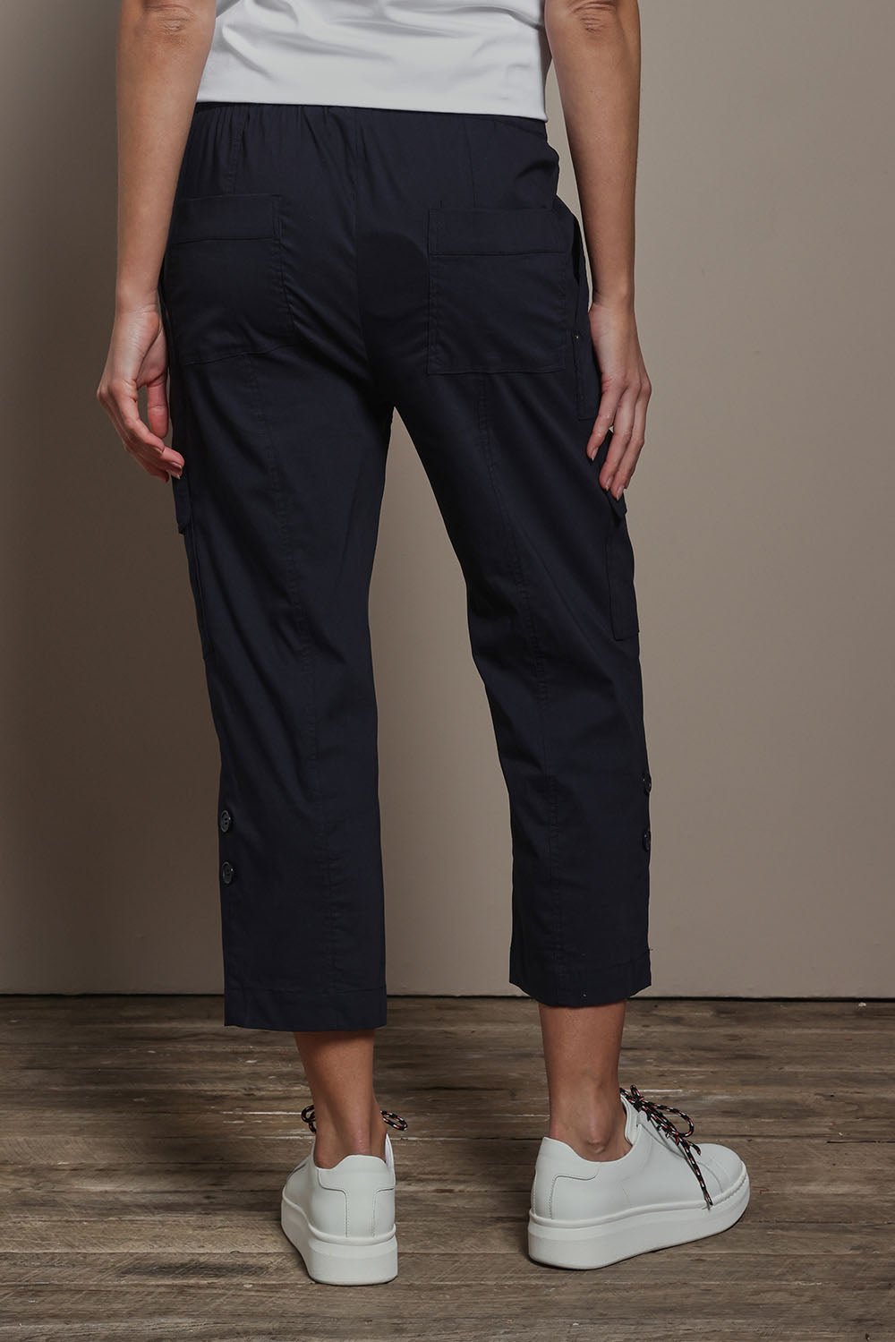 Model Madeline wearing size 10 of The Cotton Blend Cargo Pant in colour Navy (Blue), from the back