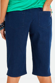 Model Vitoria wearing size 10 of The Bermuda Pull On Short in colour Denim (Blue), from the back