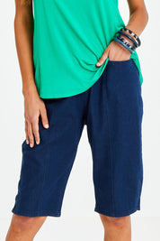 Model Vitoria wearing size 10 of The Bermuda Pull On Short in colour Denim (Blue), from the front, cropped image