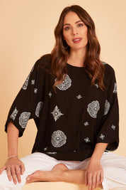 Model Madeline wearing size 10 of The Relax Fit Printed Top in colour Blkfloral (Black), from the front, showing the whole outfit