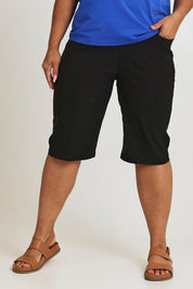 Model Ashleigh wearing size 16 of The Cargo Short in colour Black (Black), from the front, cropped image