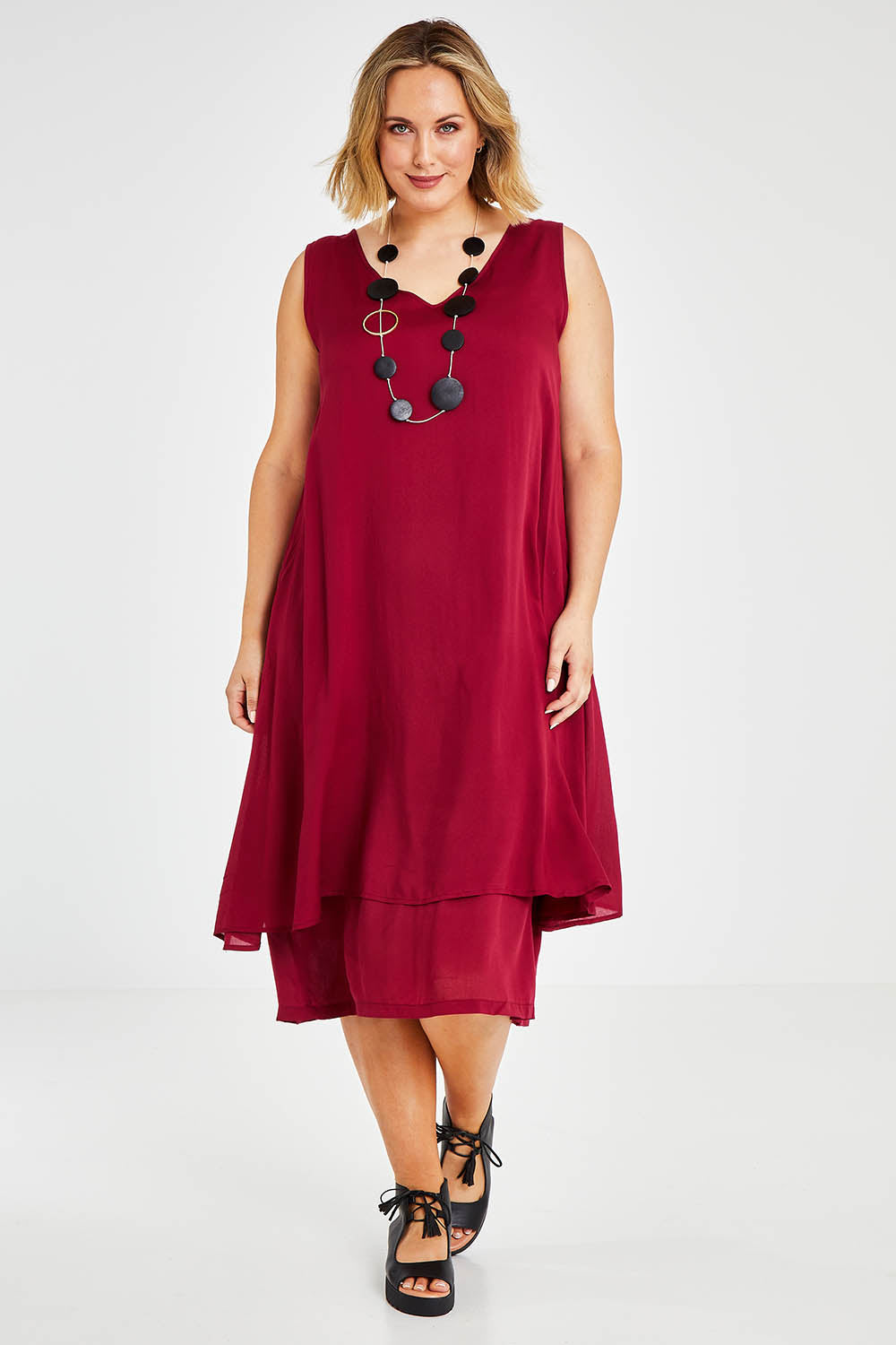 Model Jess wearing size 14 of The Everyday Layered Dress in colour Cherryred (Red), from the front, showing the whole outfit