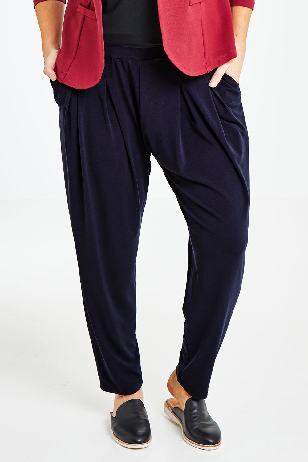 Model Laura wearing size 14 of The Pleat Detail Pull On Pant in colour Graphite (Grey), from the front, cropped image