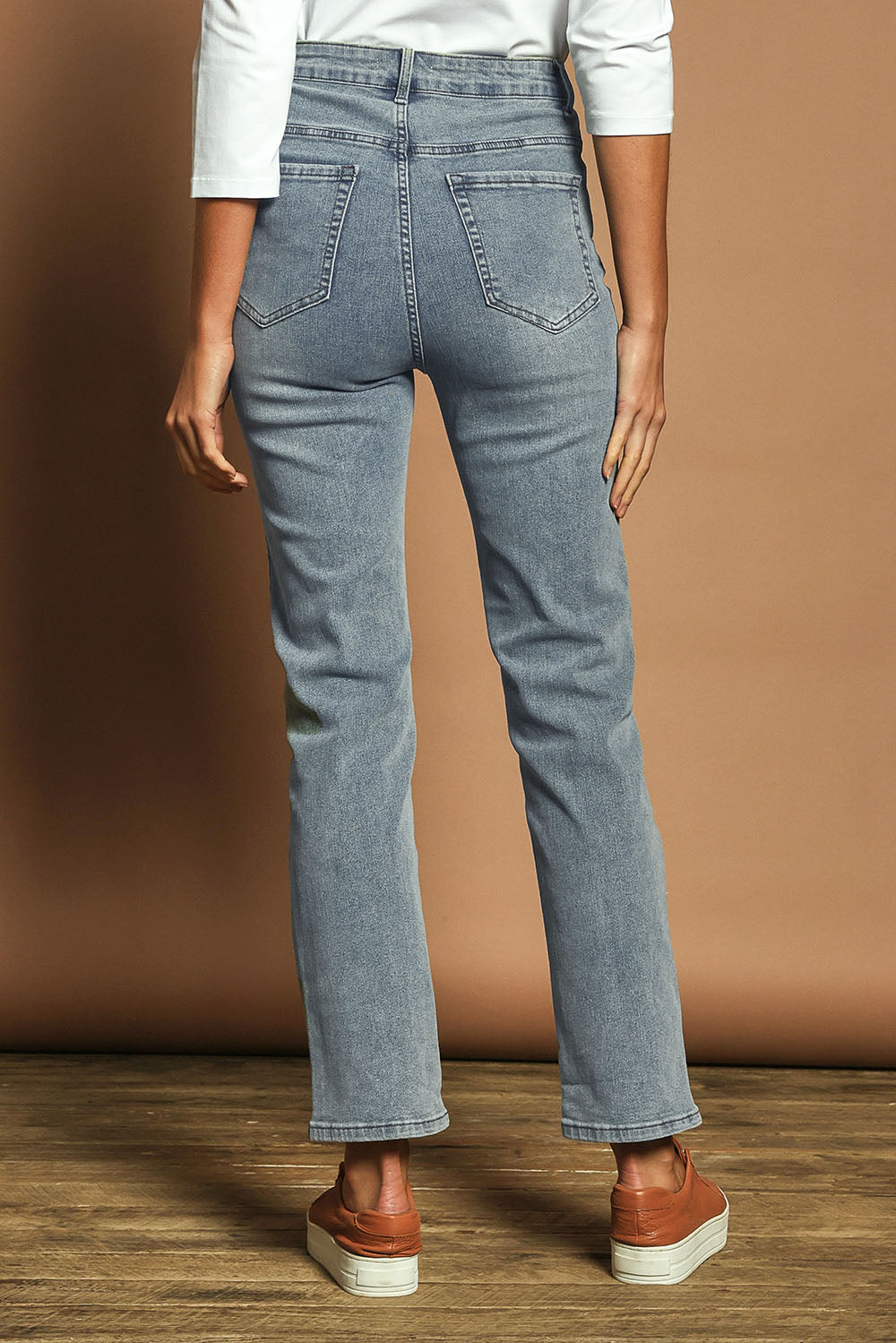 Model Madeline wearing size 10 of The Keepers Highwaisted Straight Jean in colour Lightdenim (Blue), from the back