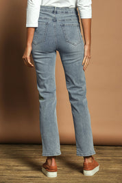 Model Madeline wearing size 10 of The Keepers Highwaisted Straight Jean in colour Lightdenim (Blue), from the back