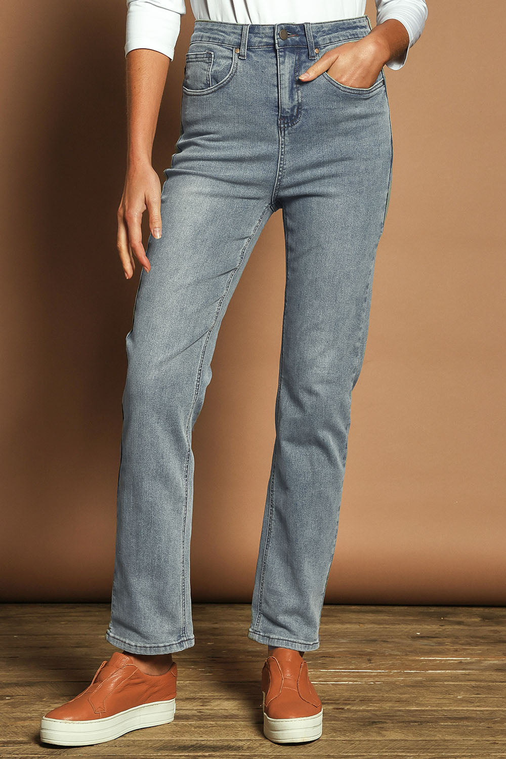 Model Madeline wearing size 10 of The Keepers Highwaisted Straight Jean in colour Lightdenim (Blue), from the front, cropped image