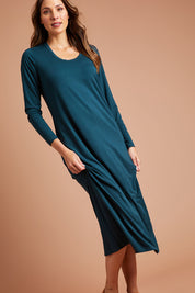 Model Madeline wearing size 10 of The Long Sleeve Bamboo Dress in colour Forest (Green), from the front, showing the whole outfit
