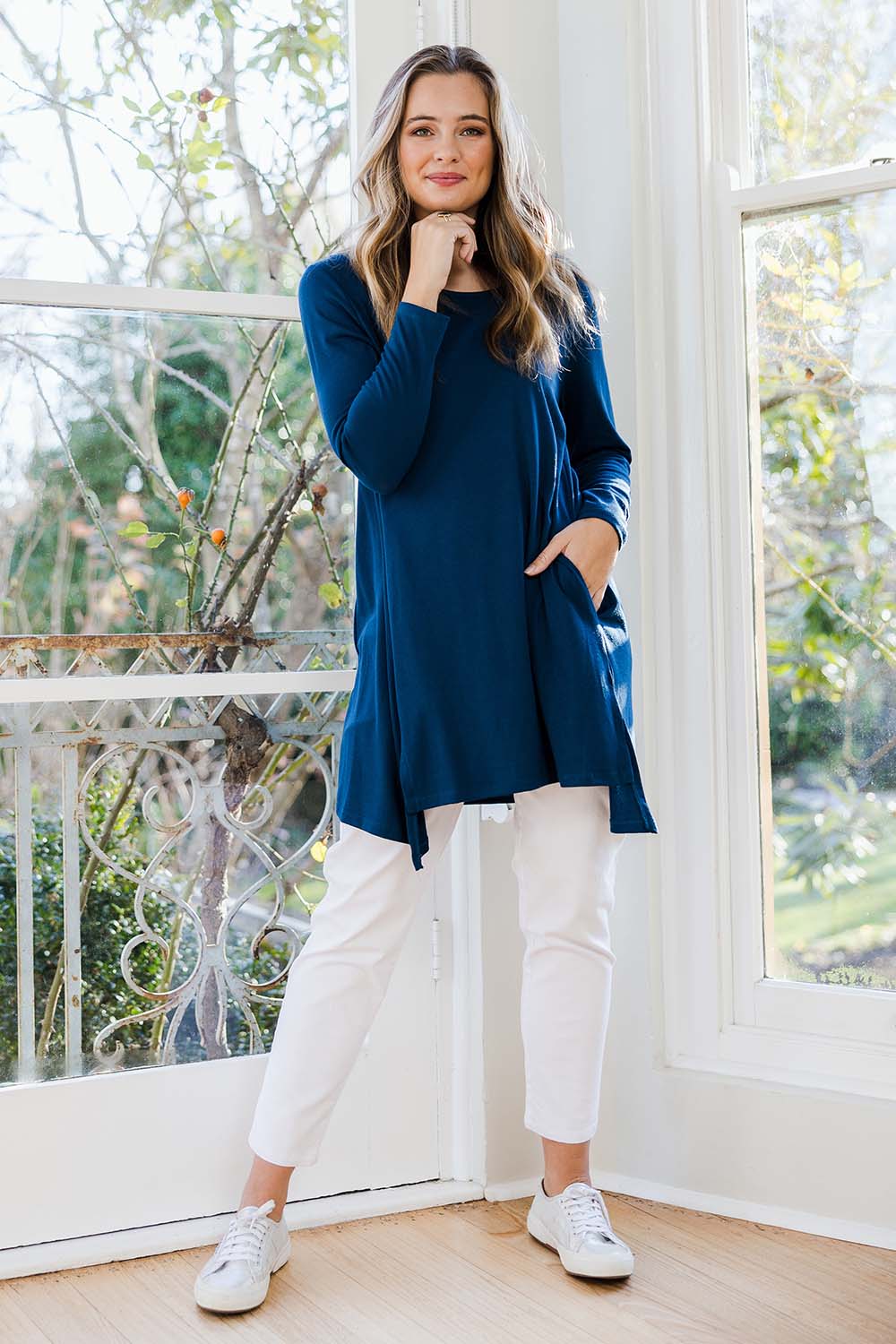 Model Tahlia wearing size 10 of The Crew Neck High Low Tunic in colour Deeplagoon (Blue), from the front, showing the whole outfit