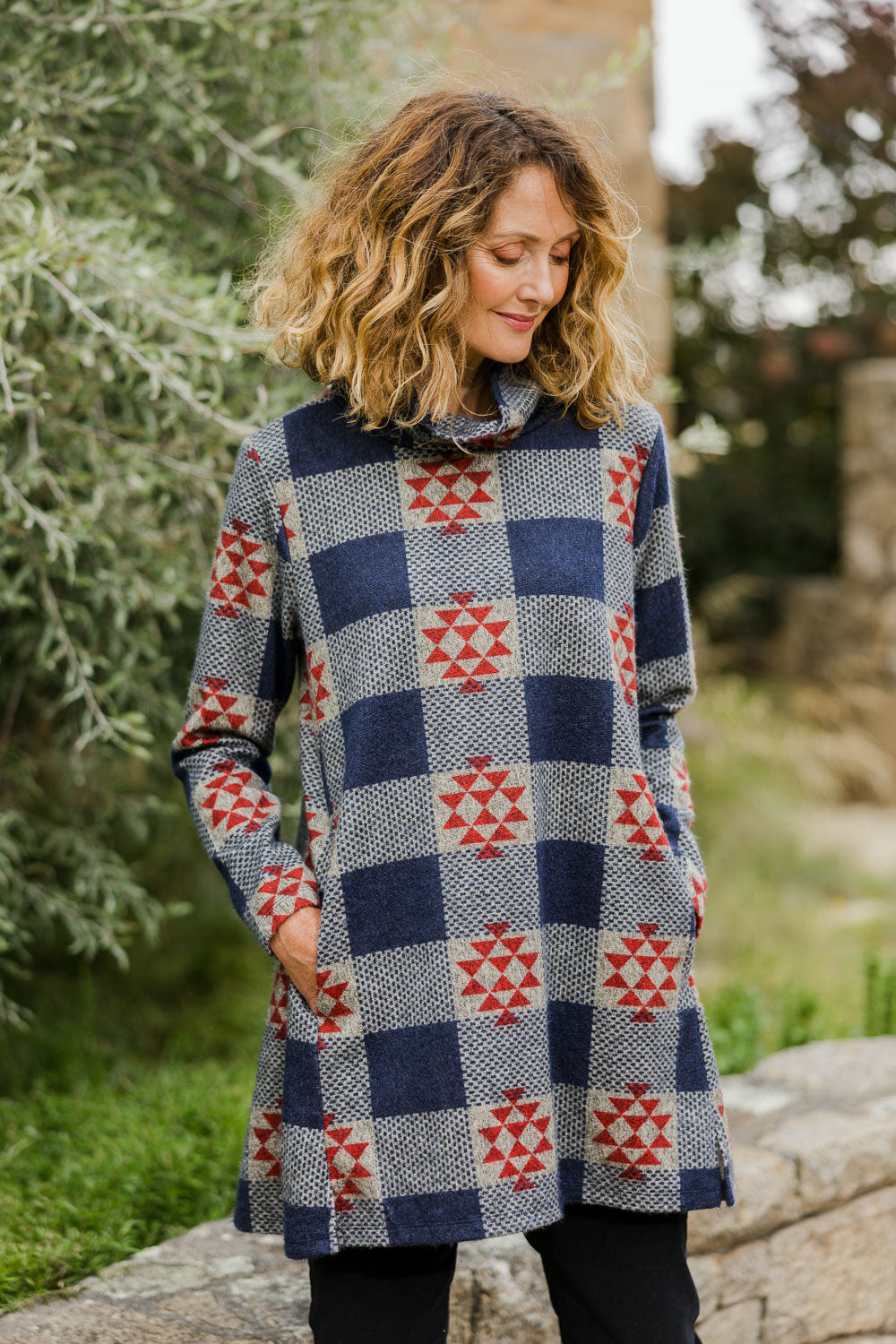 Model Emma wearing size 10 of The Woolly Knit High Low Tunic in colour Navyred (Blue), from the front, showing the whole outfit