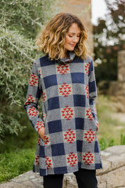 Model Emma wearing size 10 of The Woolly Knit High Low Tunic in colour Navyred (Blue), from the front, showing the whole outfit