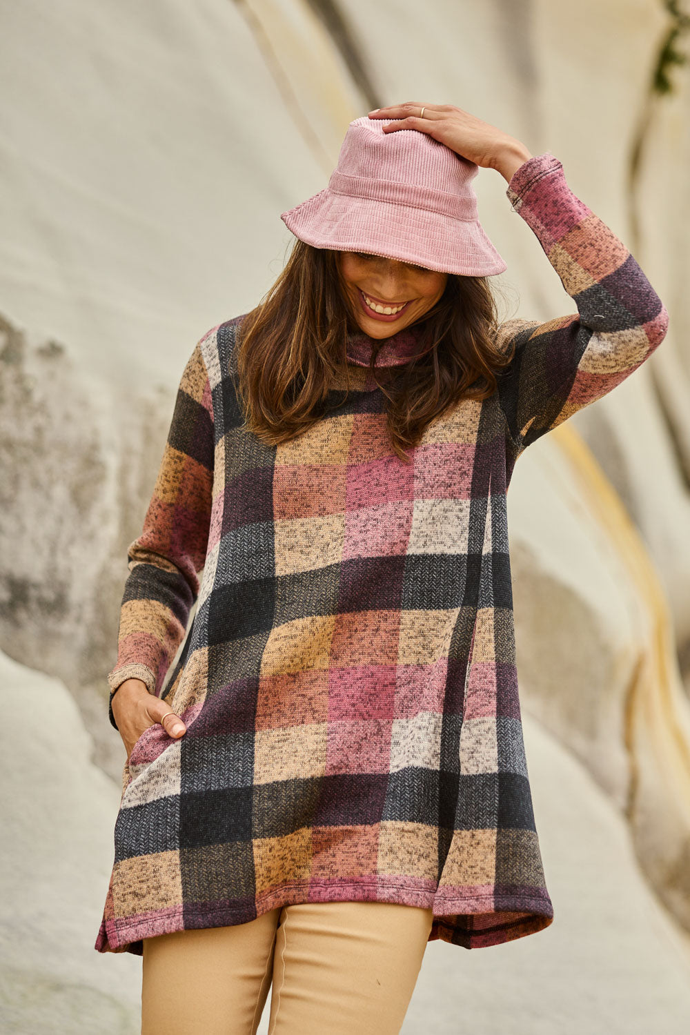 Model Amanda wearing size 10 of The Woolly Knit High Low Tunic in colour Pinkcheck (Pink), from the front, showing the whole outfit