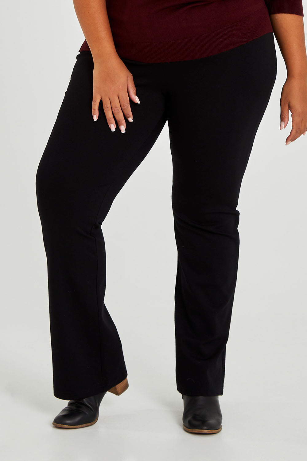Model Alexis wearing size 18 of The Pull On Ponte Boot Leg Pant in colour Black (Black), from the front, cropped image