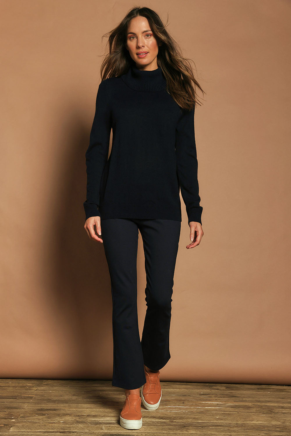 Model Madeline wearing size 10 of The Pull On Ponte Boot Leg Pant in colour Darknavy (Blue), from the front, showing the whole outfit