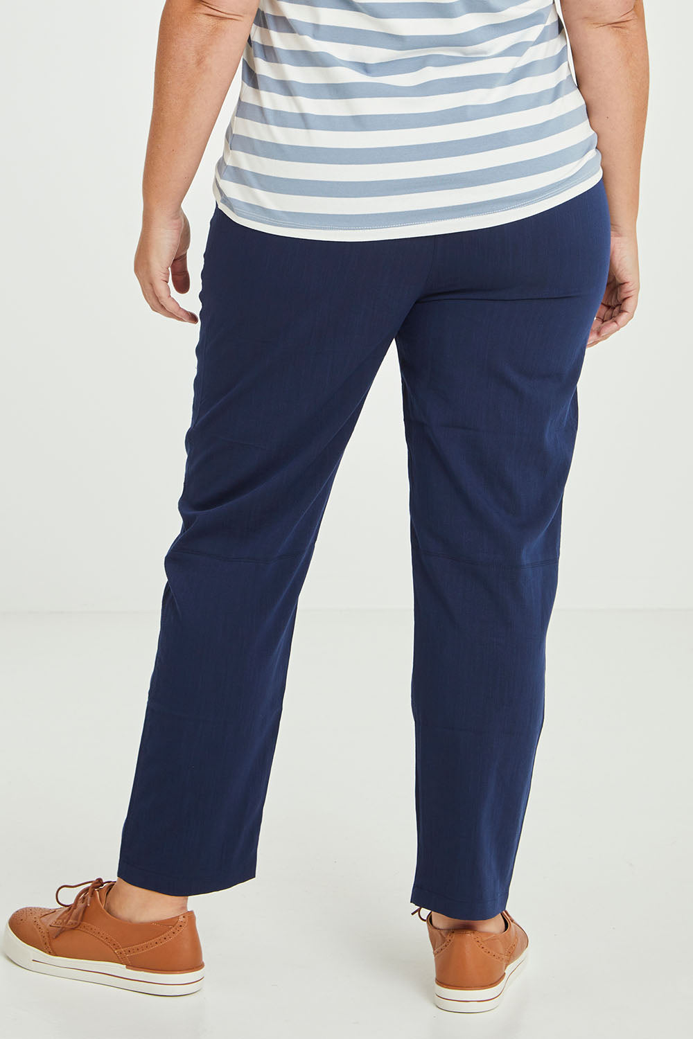 Model Fiona wearing size 16 of The Easy Wear Pant in colour Navy (Blue), from the back