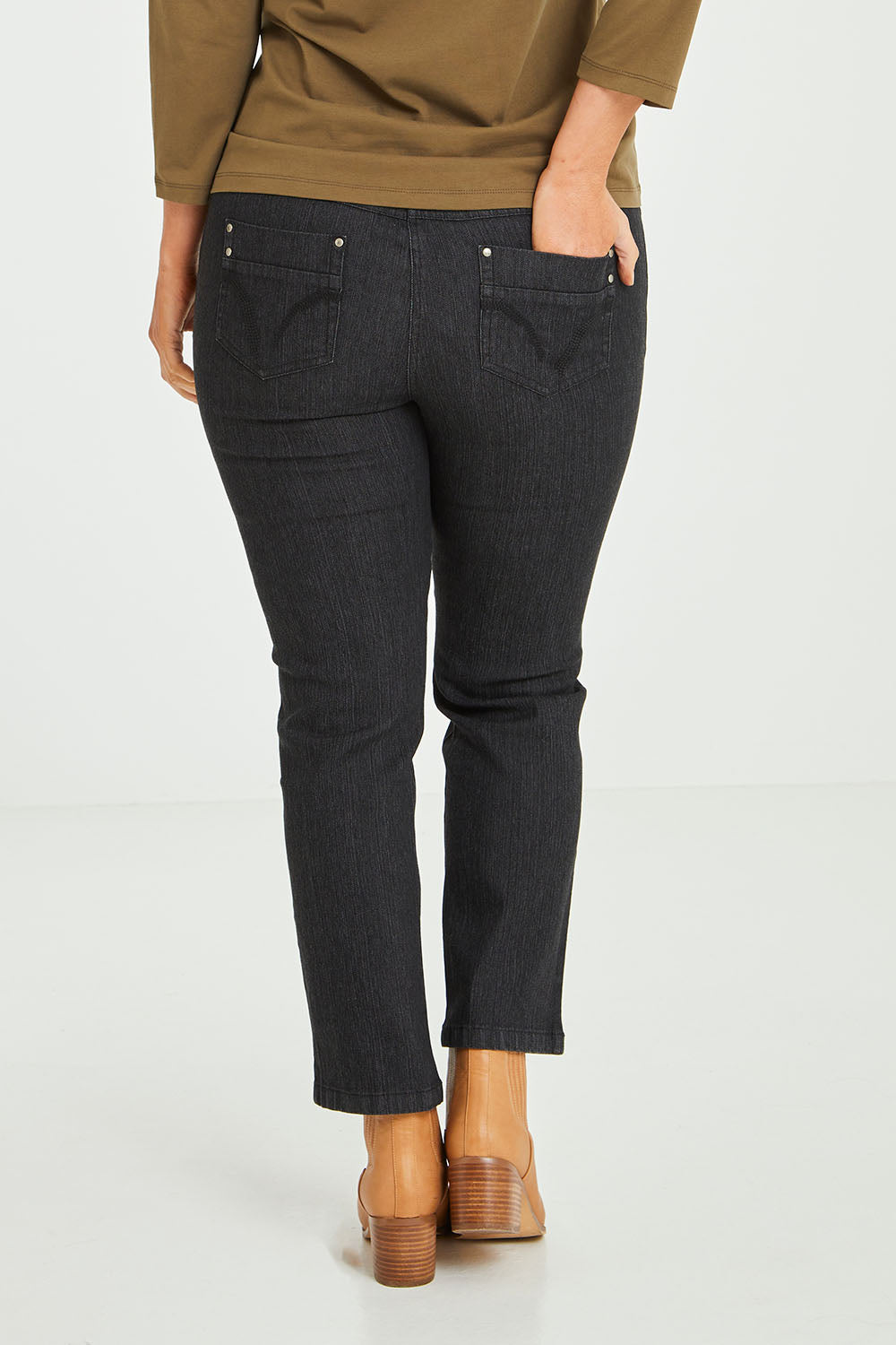Model Laura wearing size 14 of The 7/8 Pull On Jean in colour Blackdenim (Black), from the back