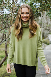 Model Tahlia wearing size S of The Essential Soft High Low Jumper in colour Avocado (Green), from the front, showing the whole outfit