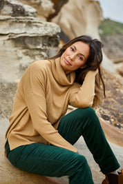 Model Amanda wearing size S of The Essential Soft High Low Jumper in colour Biscuit, from the front, showing the whole outfit