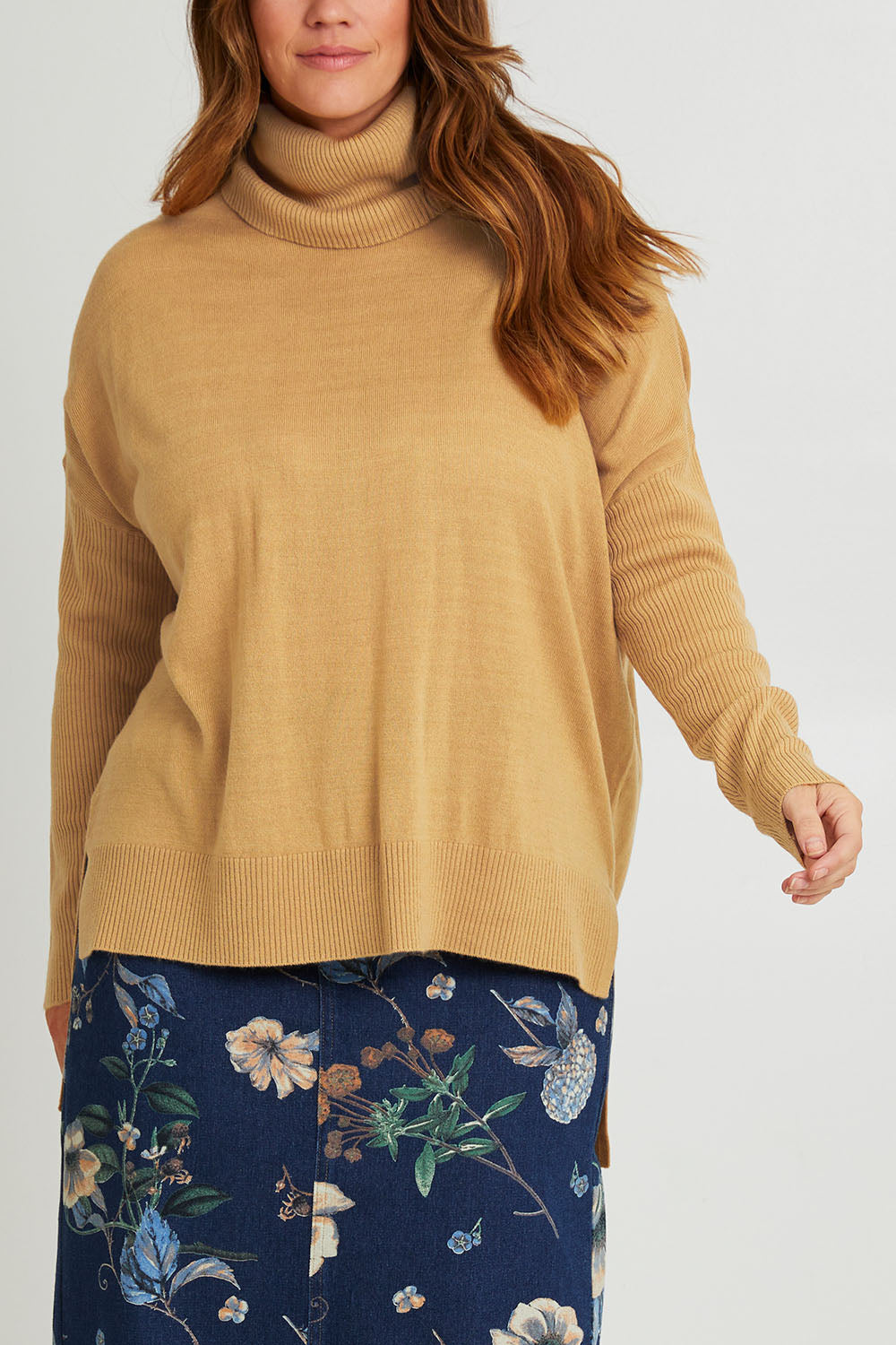 Model Laura wearing size L of The Essential Soft High Low Jumper in colour Biscuit, from the front, cropped image