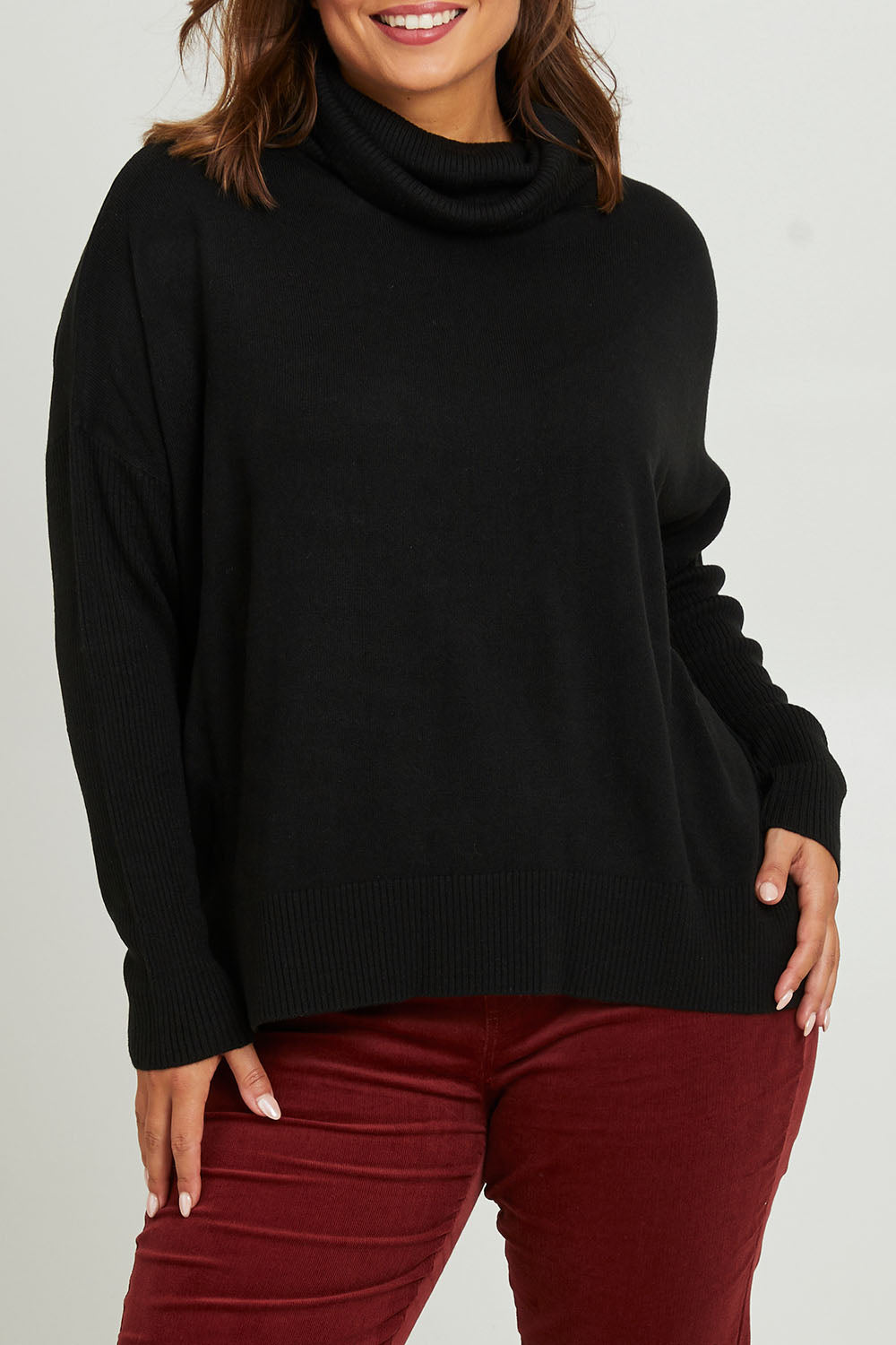 Model Monique wearing size S of The Essential Soft High Low Jumper in colour Black (Black), from the front, cropped image