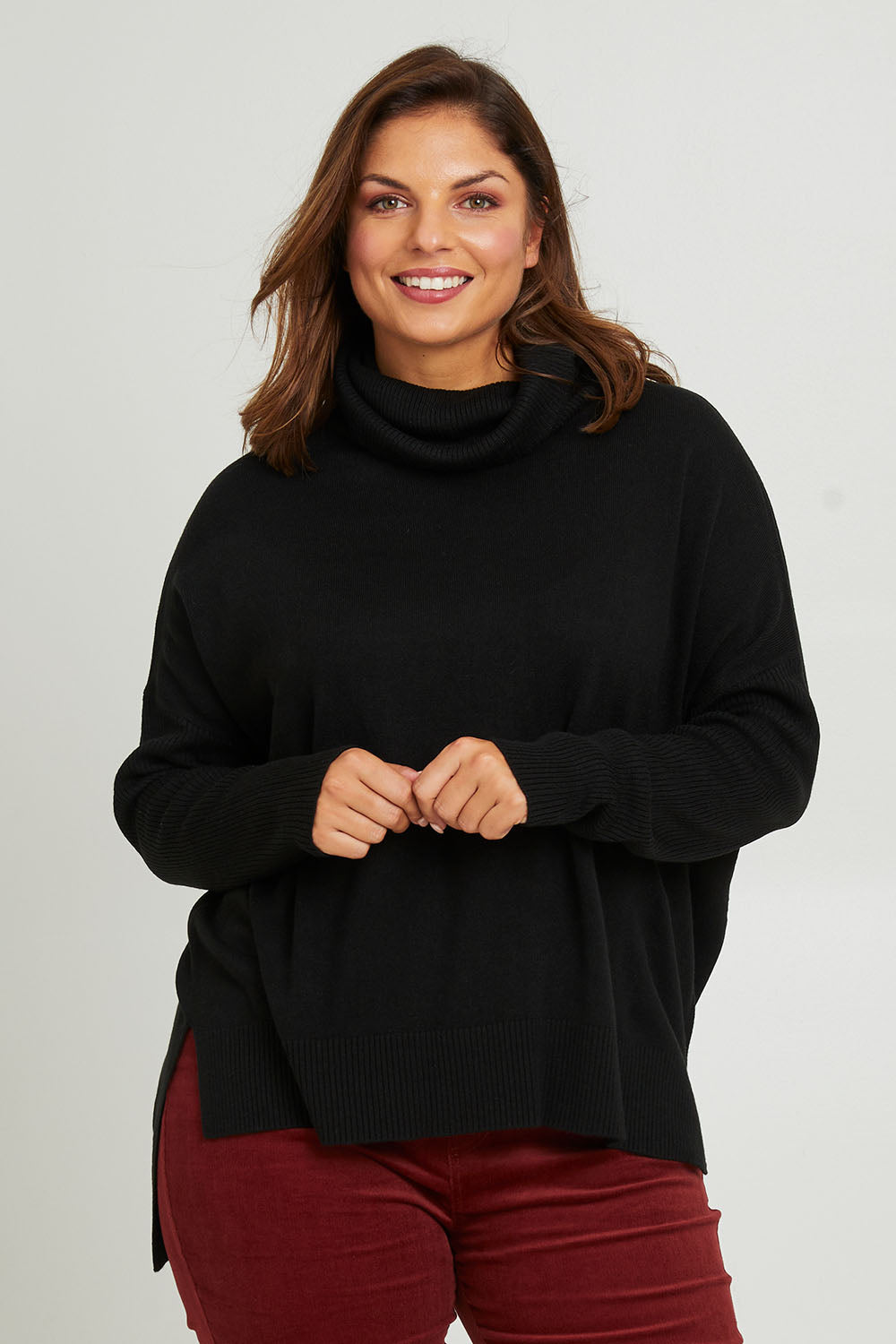 Model Monique wearing size S of The Essential Soft High Low Jumper in colour Black (Black), from the front, cropped image