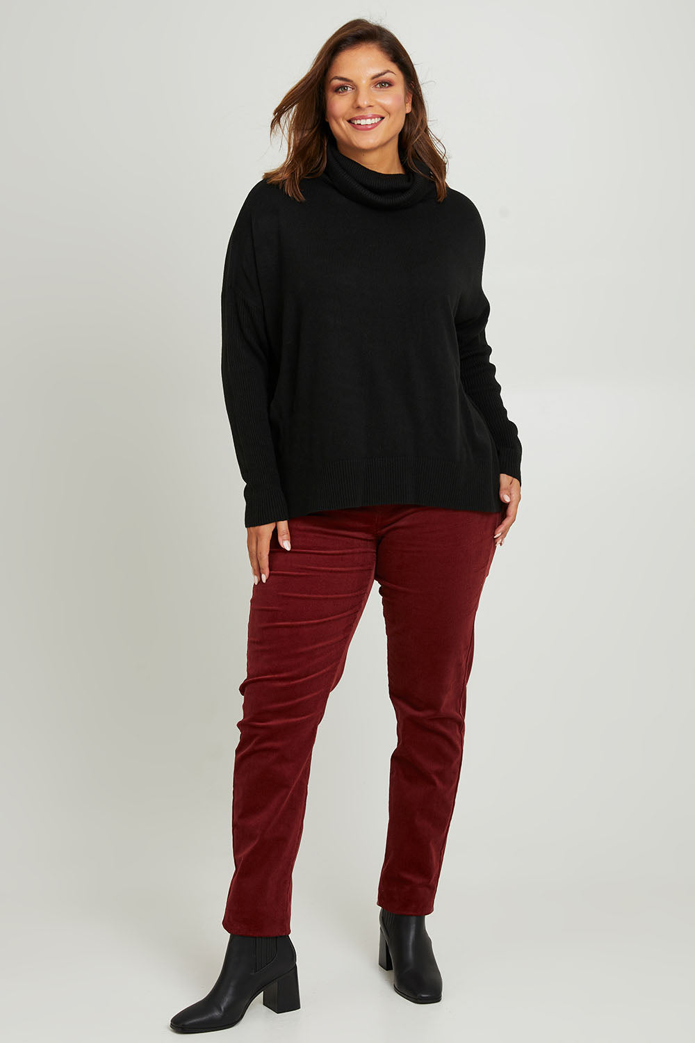 Model Monique wearing size S of The Essential Soft High Low Jumper in colour Black (Black), from the front, showing the whole outfit