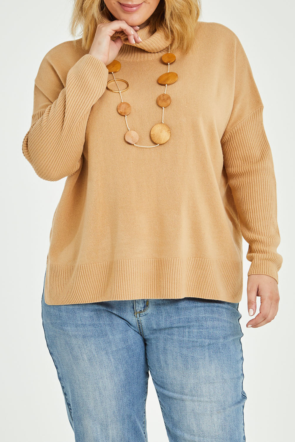 Model Jess wearing size L of The Essential Soft High Low Jumper in colour Camel, from the front, cropped image