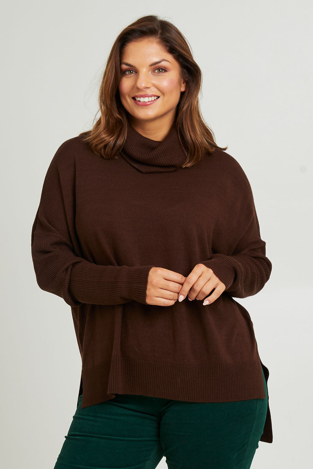 Model Monique wearing size L of The Essential Soft High Low Jumper in colour Chocolate, from the front, cropped image