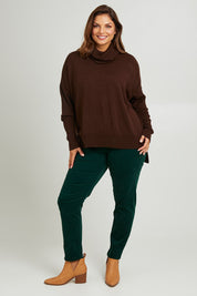 Model Monique wearing size L of The Essential Soft High Low Jumper in colour Chocolate, from the front, showing the whole outfit