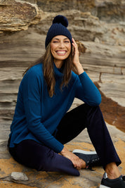 Model Amanda wearing size S of The Essential Soft High Low Jumper in colour Petrol (Blue), from the front, showing the whole outfit
