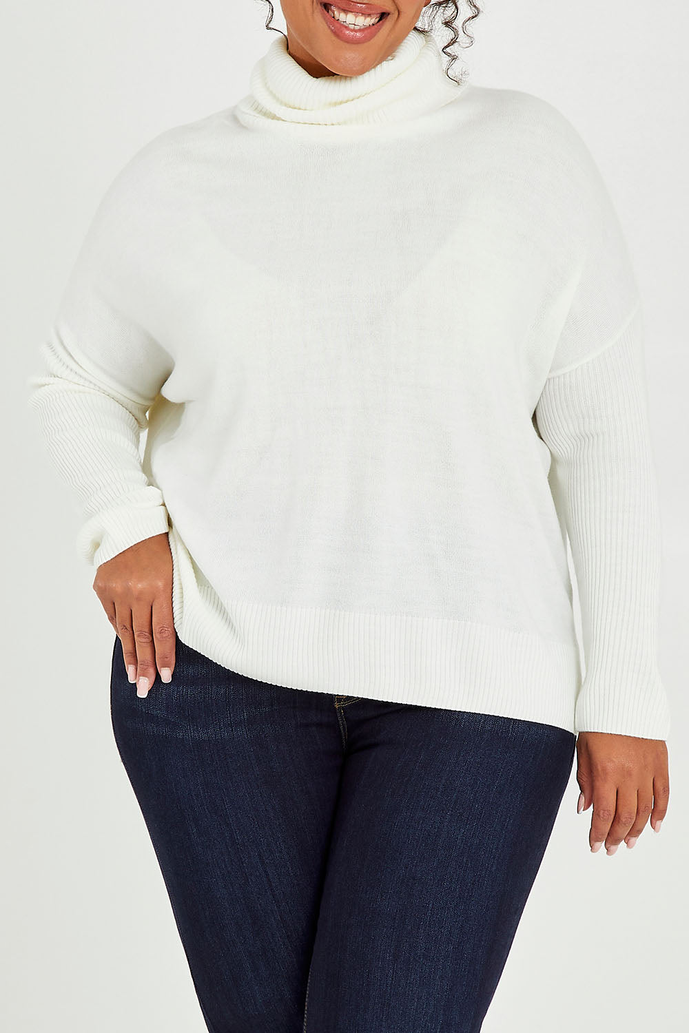 Model Alexis wearing size XL of The Essential Soft High Low Jumper in colour Snow (White), from the front, cropped image