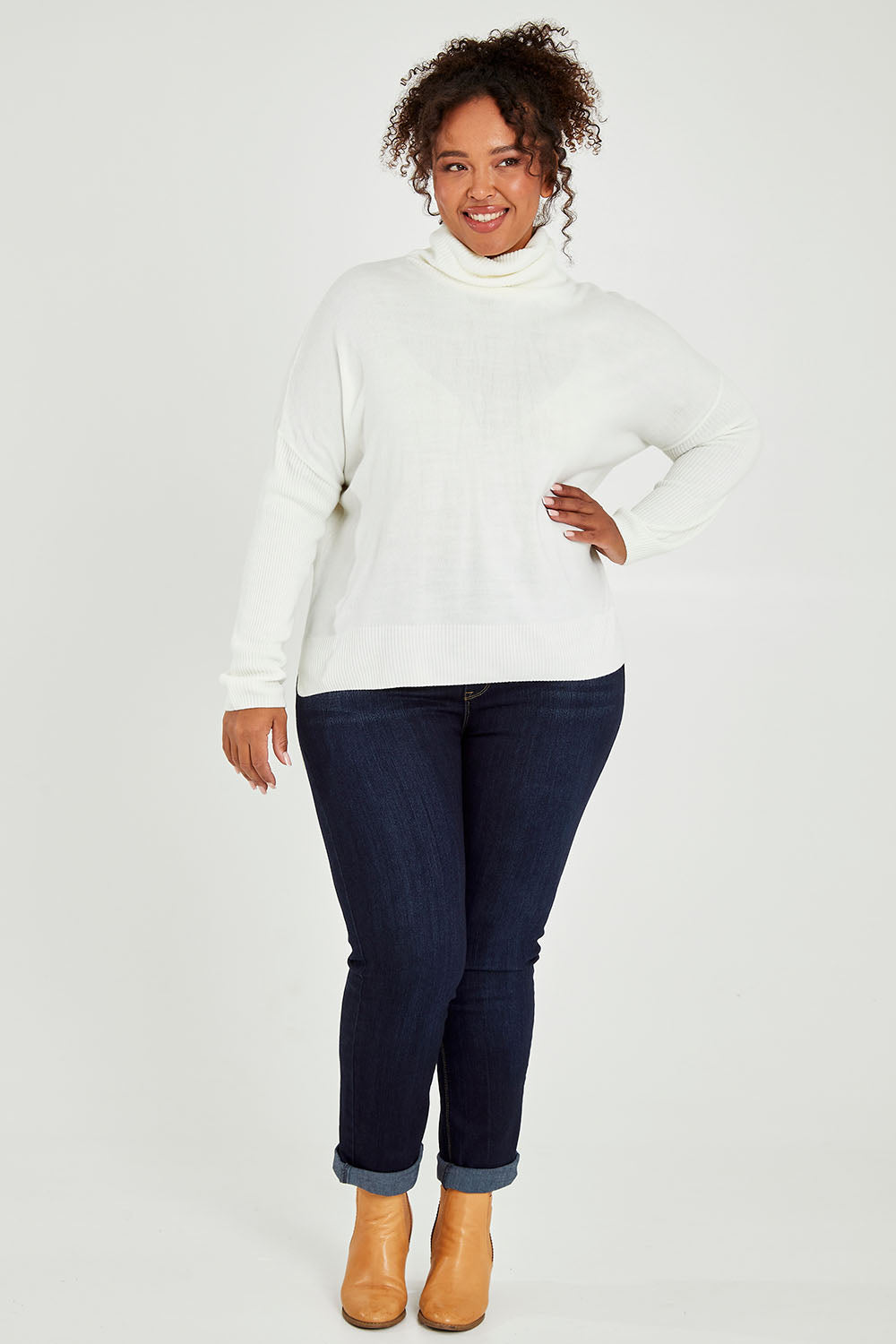 Model Alexis wearing size XL of The Essential Soft High Low Jumper in colour Snow (White), from the front, showing the whole outfit