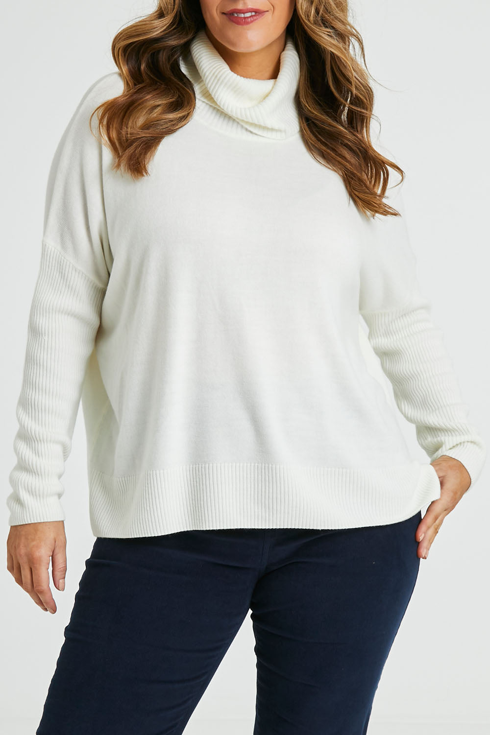 Model Laura wearing size L of The Essential Soft High Low Jumper in colour Snow (White), from the front, cropped image