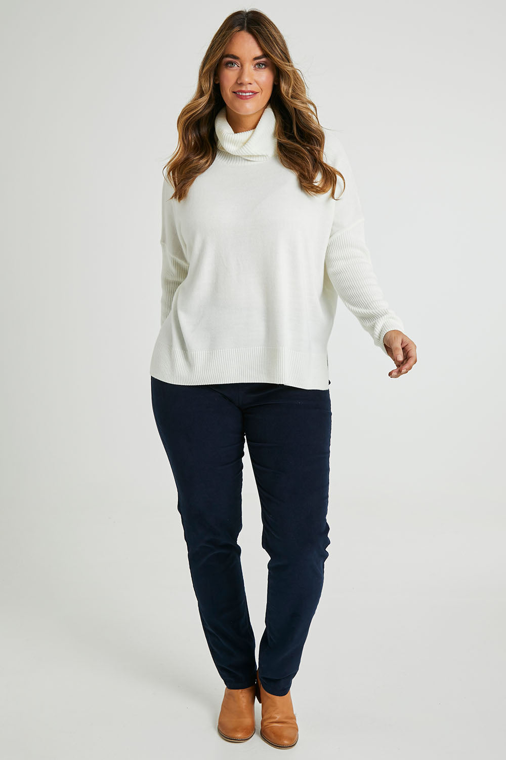 Model Laura wearing size L of The Essential Soft High Low Jumper in colour Snow (White), from the front, showing the whole outfit