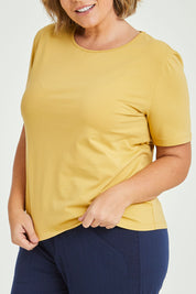 Model Fiona wearing size 16 of The Keepers Tee in colour Camel, from the front, cropped image