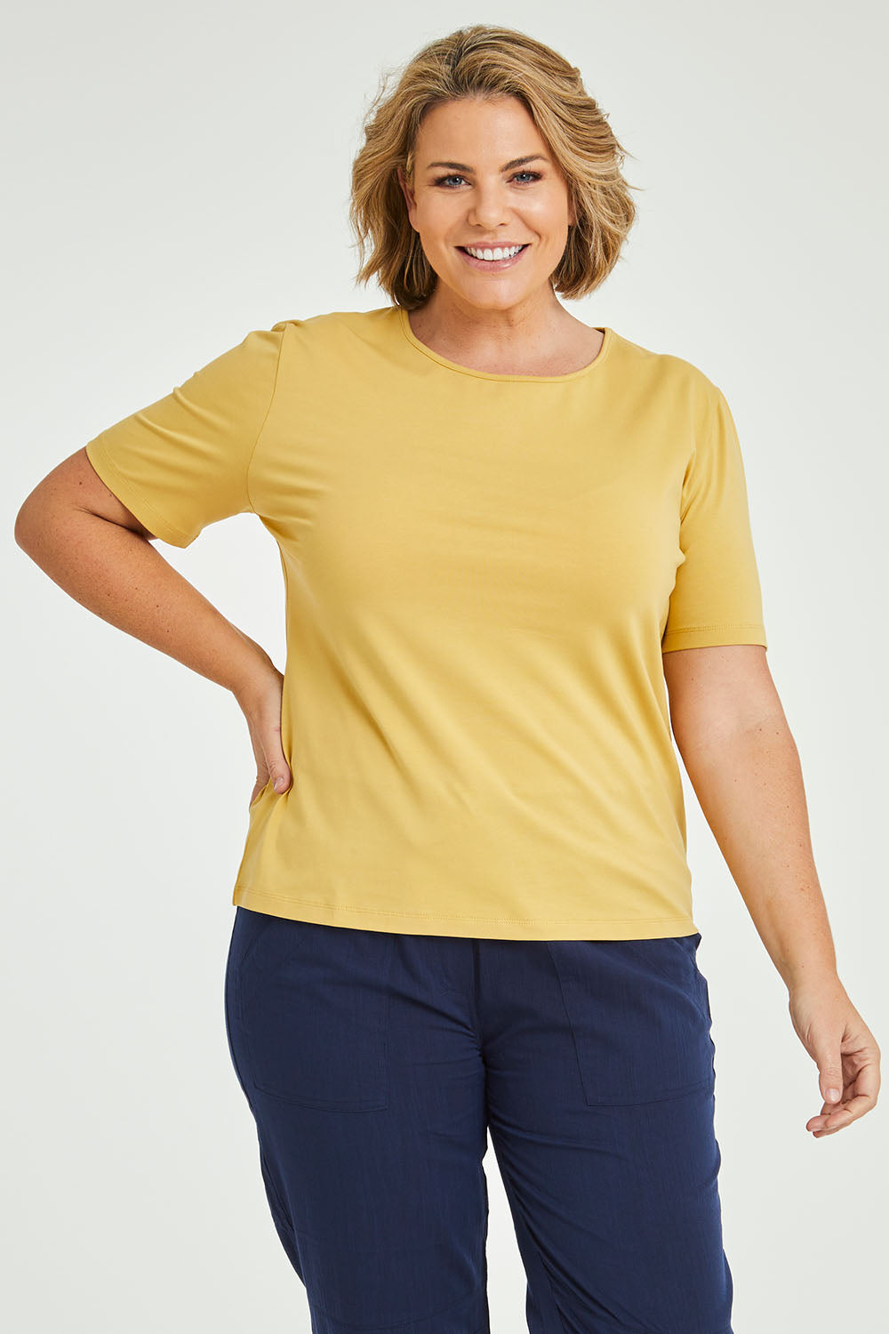 Model Fiona wearing size 16 of The Keepers Tee in colour Camel, from the front, cropped image