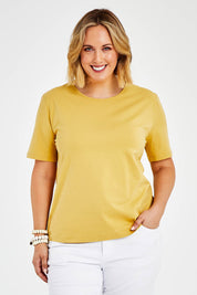 Model Jess wearing size 14 of The Keepers Tee in colour Camel, from the front, cropped image