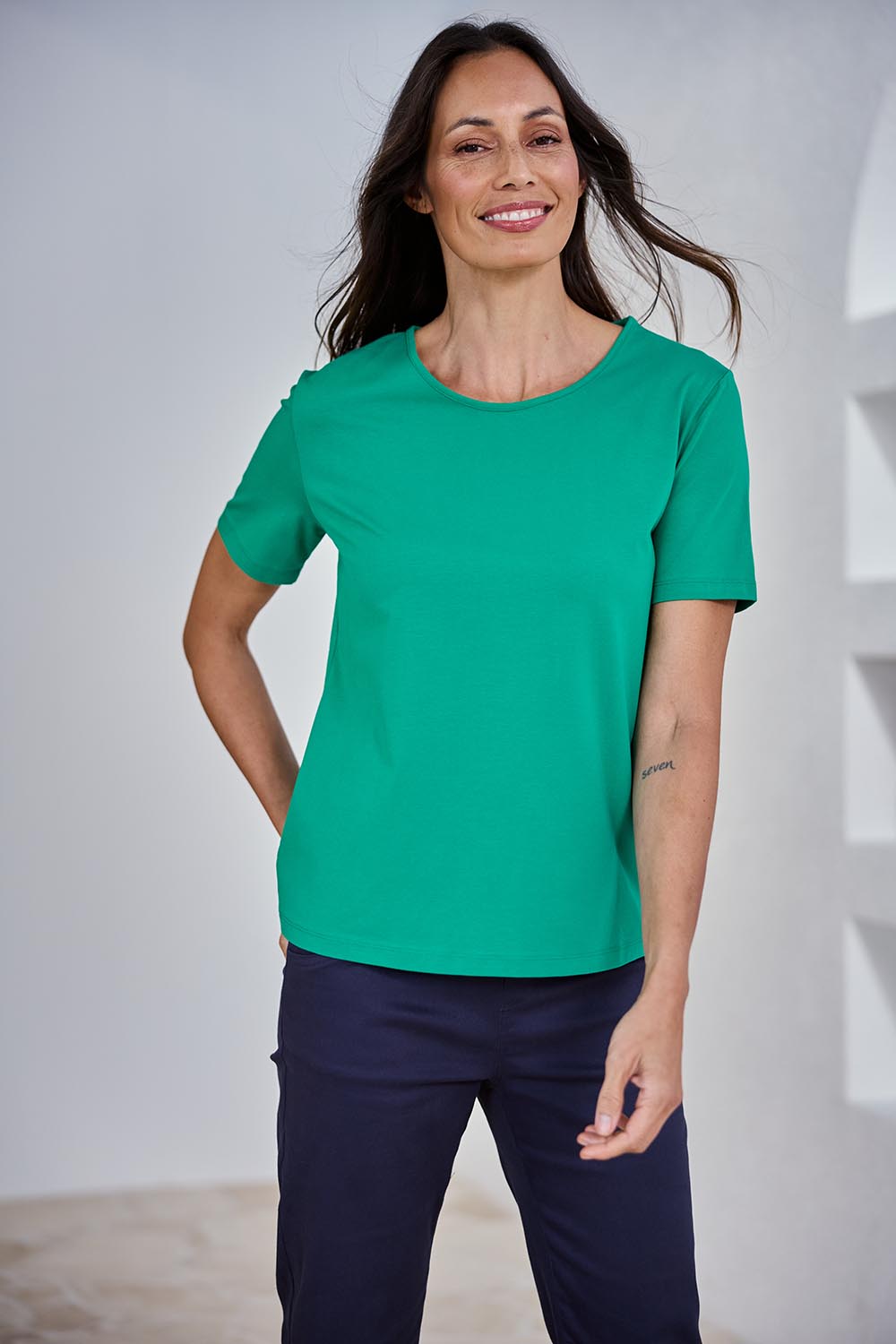Model Amanda wearing size 10 of The Keepers Tee in colour Emerald (Green), from the front, showing the whole outfit