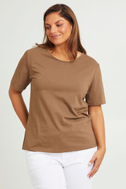 Model Monique wearing size 14 of The Keepers Tee in colour Mushroom, from the front, cropped image